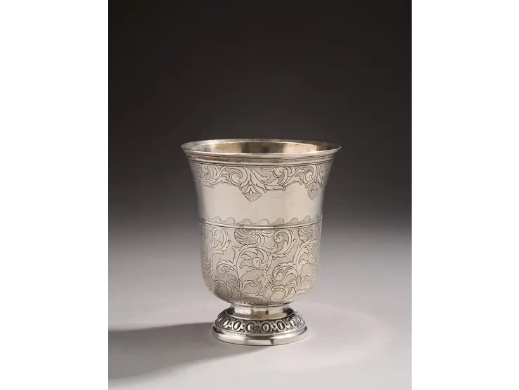 Timbale en argent de forme tulipe reposant sur un piédouche ciselé d’oves et de miroirs.