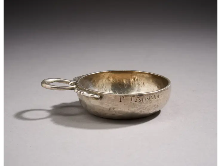 Une tasse à vin en argent à décor uni, la prise en serpent, la bordure gravée F Fainon.