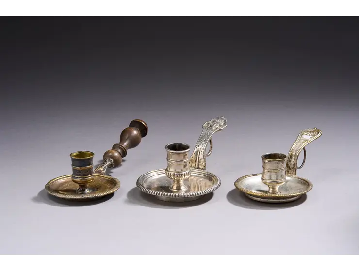Lot de trois bougeoirs en métal argenté à décor de godrons.