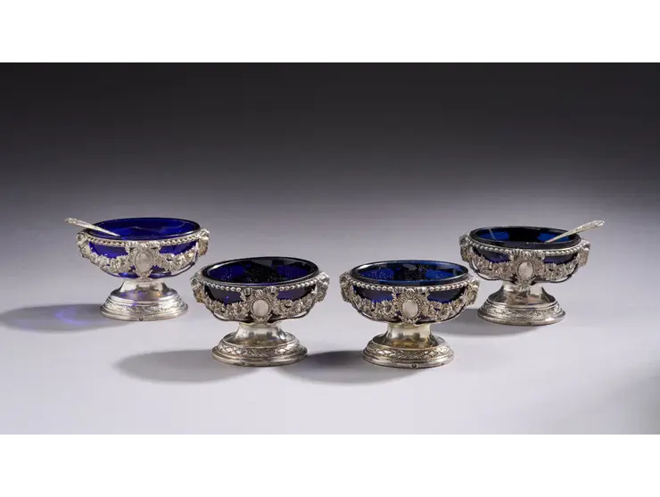Paire de salières en argent en forme de petites vasques ovales reposant sur un pied à doucines et frises de feuillages rubanés.