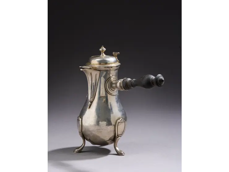 Verseuse de forme balustre en argent reposant sur trois pieds à enroulements, le corps uni.