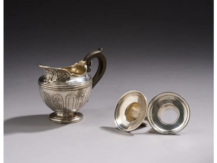 Crémier en métal argenté à décor de lambrequins, coquilles et enroulements.