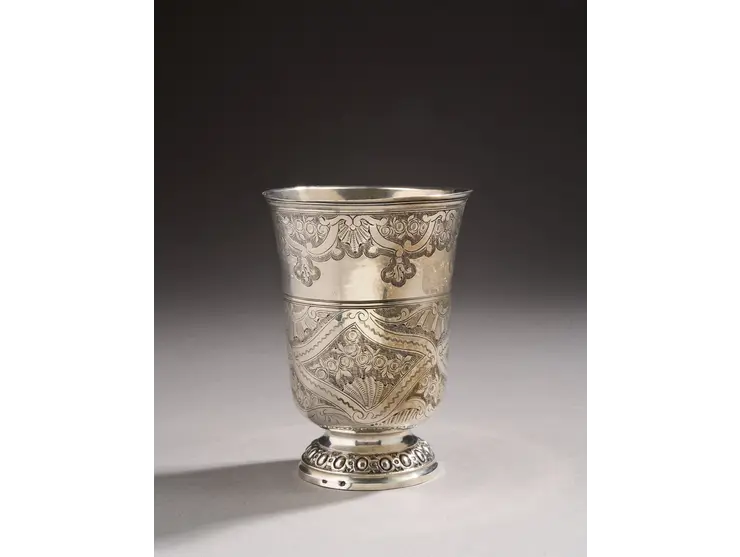 Timbale en argent de forme tulipe reposant sur un piédouche ciselé d’oves et de miroirs.